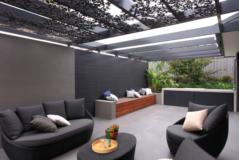 Idée de décoration pour une terrasse latérale minimaliste de taille moyenne avec une cuisine d'été, du carrelage et une pergola.