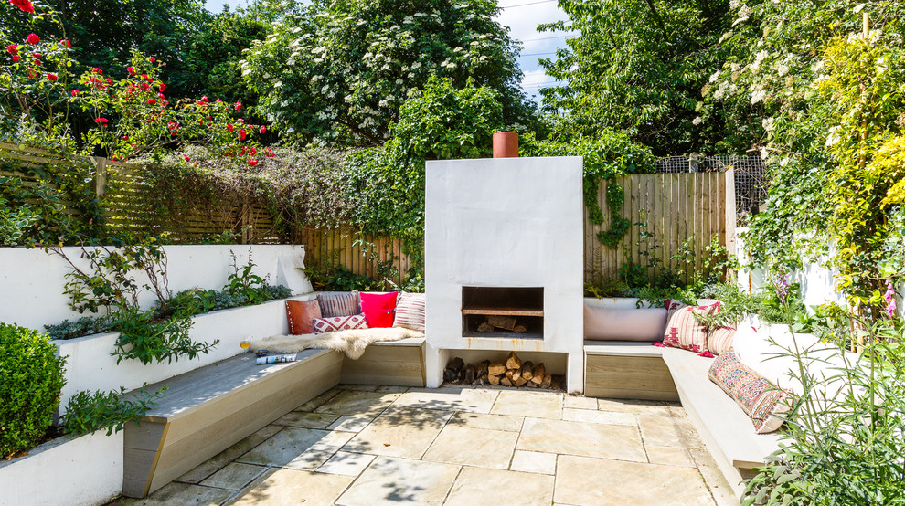 Photo of an eclectic patio in New York with tiled flooring, no cover and fencing.