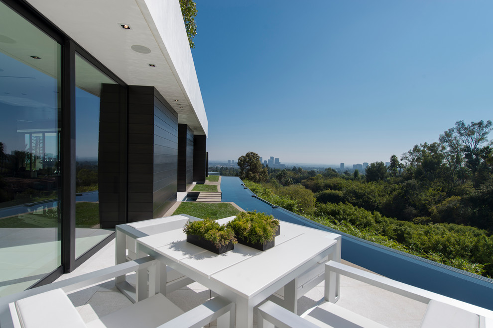 Photo of an expansive modern side patio in Los Angeles with a water feature, tiled flooring and no cover.