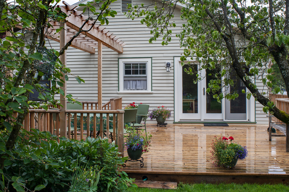 Example of a mid-sized classic backyard patio design in Portland with decking and a pergola