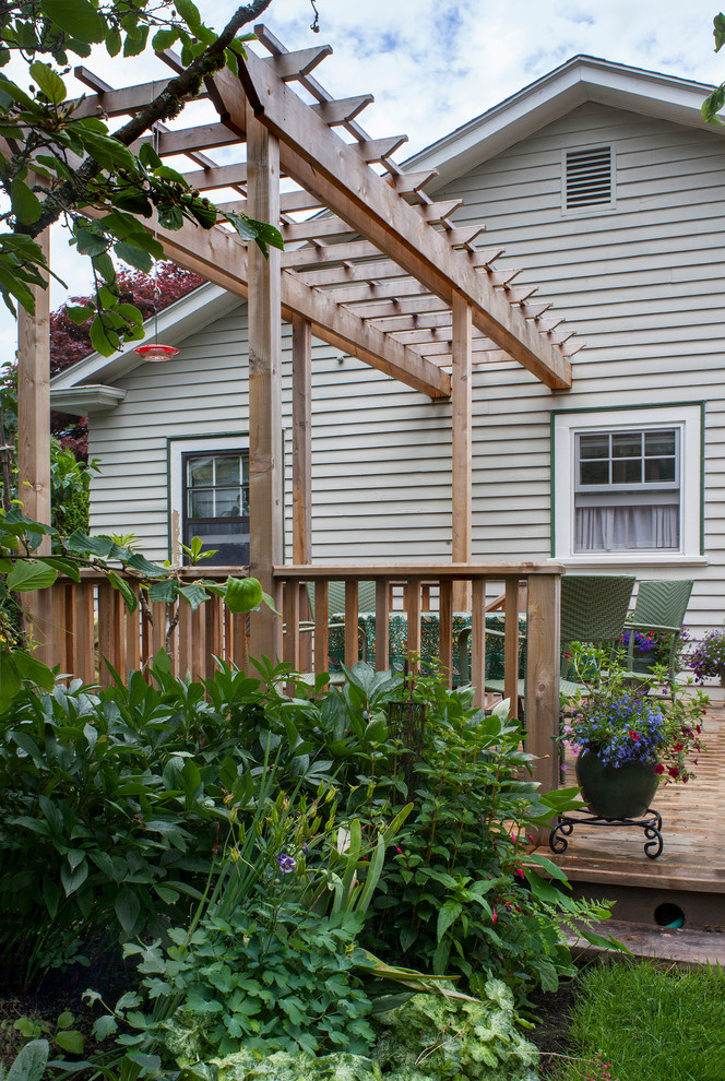 Ispirazione per un patio o portico tradizionale di medie dimensioni e dietro casa con pedane e una pergola