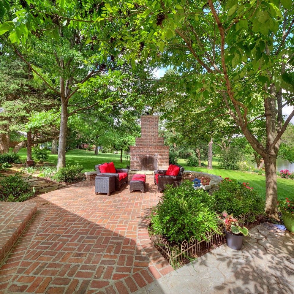 Inspiration for a huge timeless backyard brick patio remodel in Kansas City with a fire pit and no cover