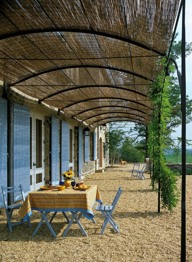 Photo of a country patio in DC Metro with gravel and a pergola.