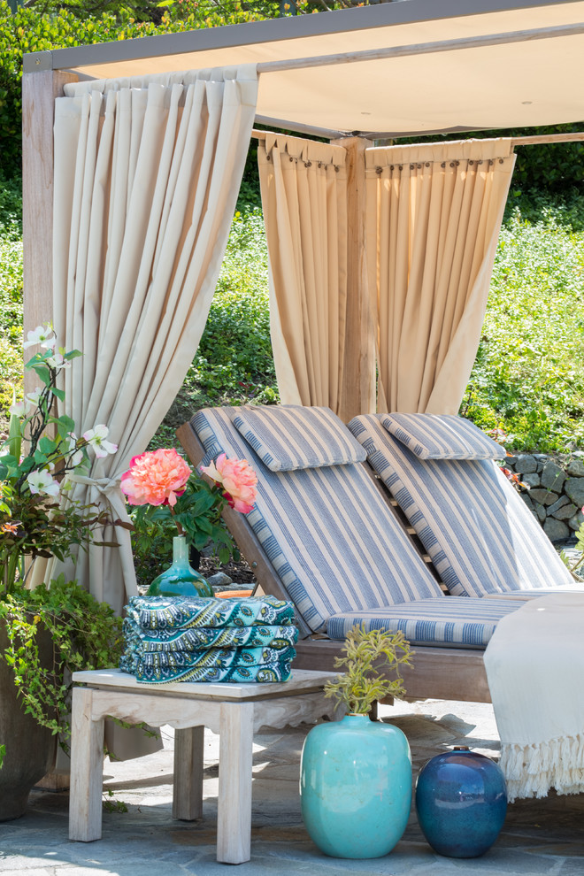 Foto di un grande patio o portico design dietro casa con pavimentazioni in pietra naturale e un parasole