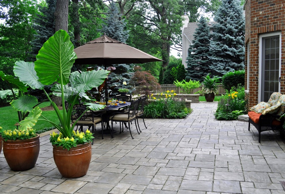 Imagen de patio clásico grande sin cubierta en patio trasero con brasero y adoquines de ladrillo