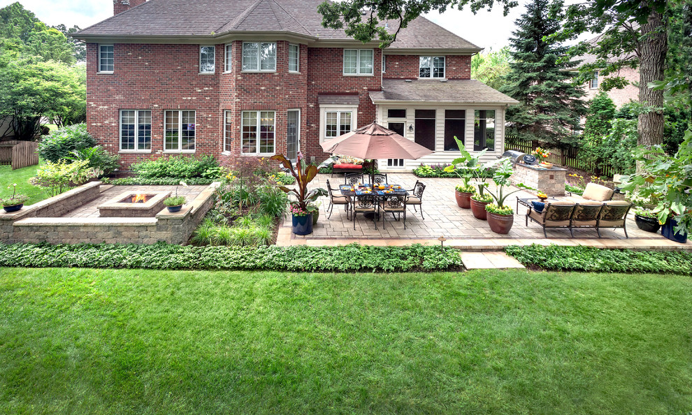 На фото: большой двор на заднем дворе в классическом стиле с местом для костра и мощением клинкерной брусчаткой без защиты от солнца
