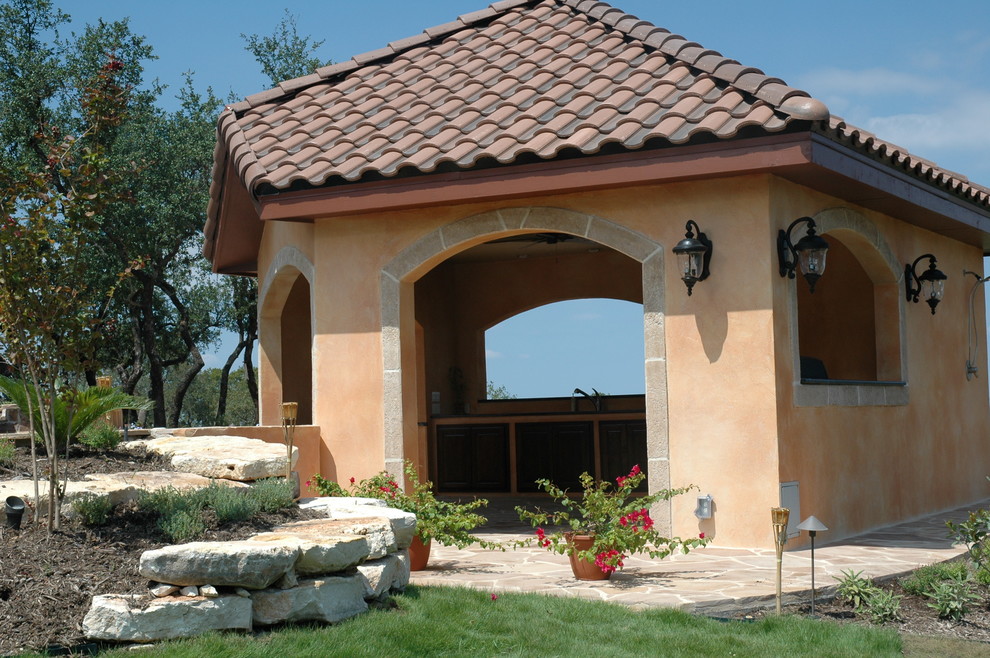 Immagine di un patio o portico mediterraneo di medie dimensioni e dietro casa con pavimentazioni in pietra naturale