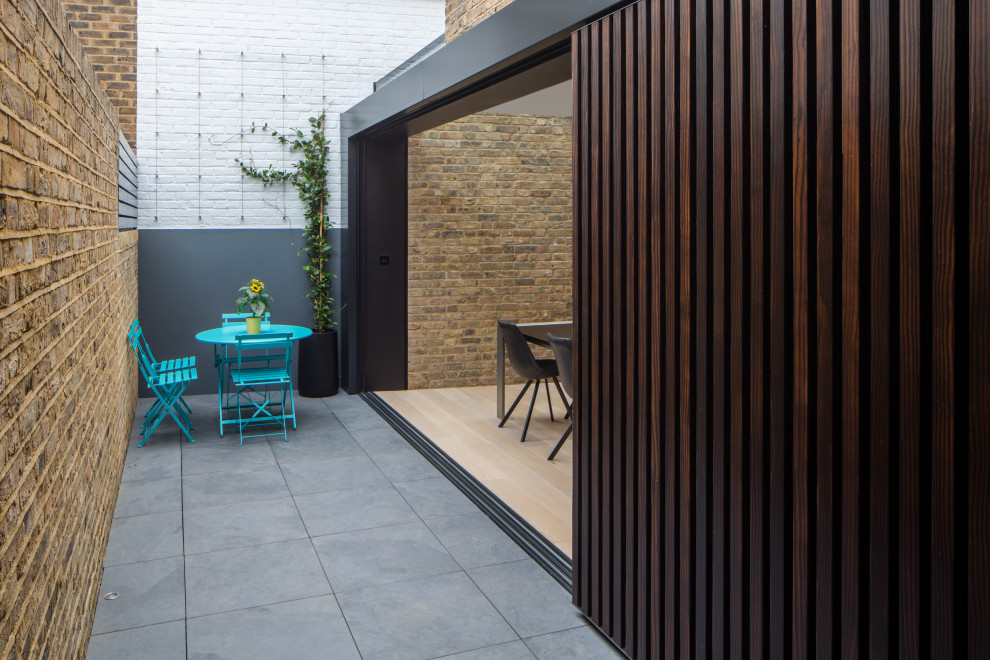 Foto di un patio o portico minimalista con piastrelle