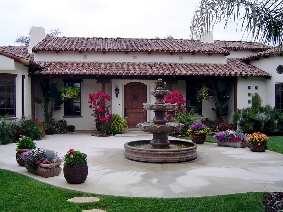 Стильный дизайн: двор на внутреннем дворе в средиземноморском стиле с фонтаном и покрытием из бетонных плит без защиты от солнца - последний тренд