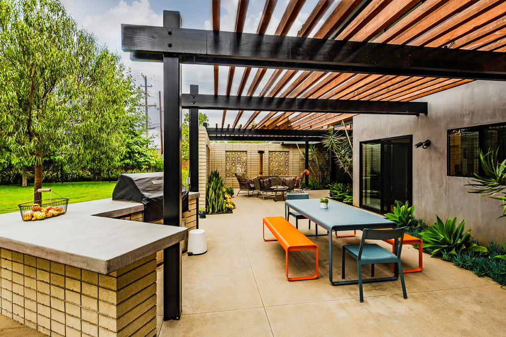 Imagen de patio vintage grande en patio lateral con chimenea, losas de hormigón y pérgola