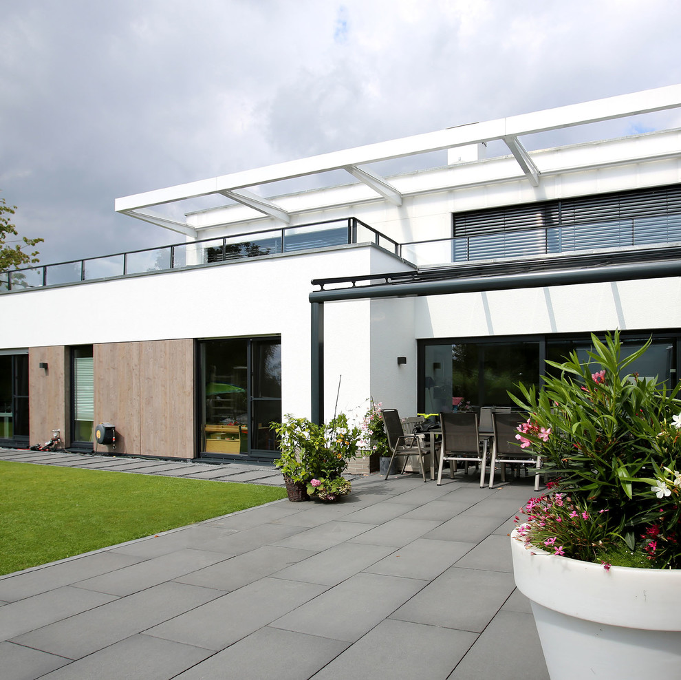 Photo of a large modern back patio in Essen with a pergola and a potted garden.