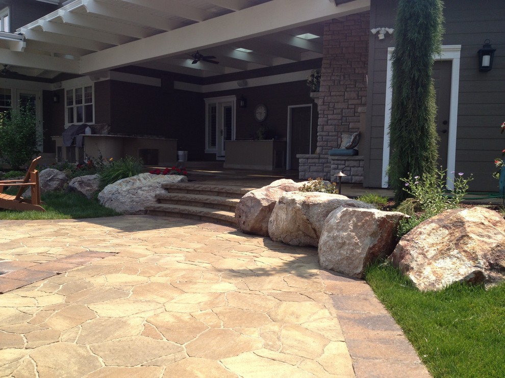 Example of a huge classic backyard concrete paver patio kitchen design in Boise with a roof extension