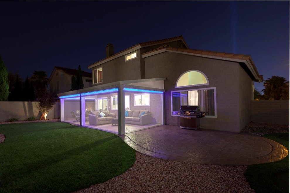 Foto di un patio o portico mediterraneo di medie dimensioni e dietro casa con lastre di cemento e un parasole