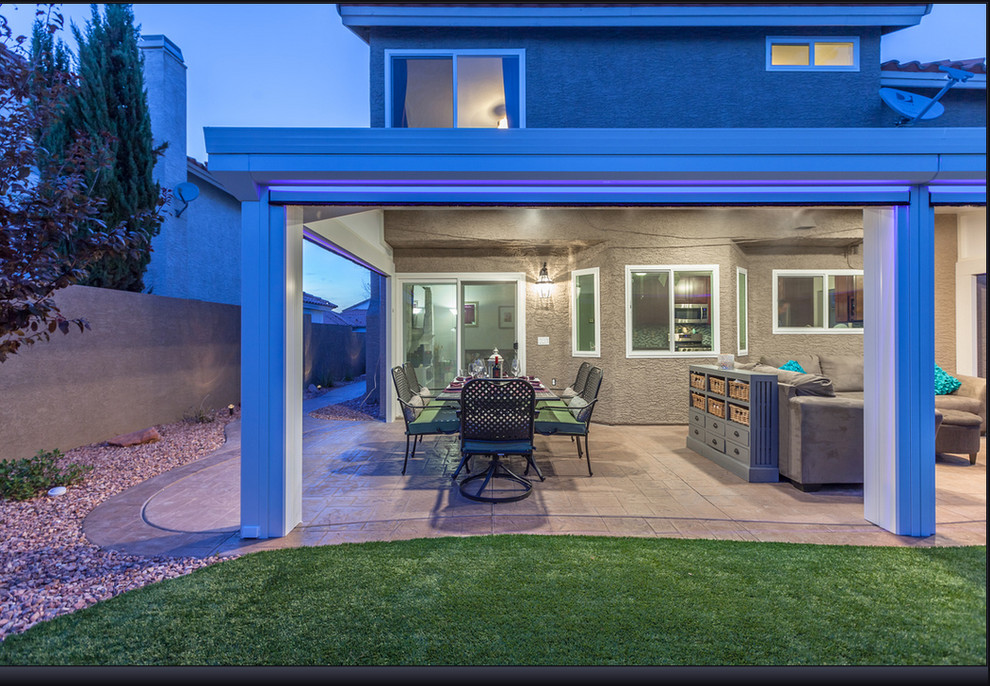 Example of a mid-sized tuscan backyard concrete patio design in Sacramento with an awning