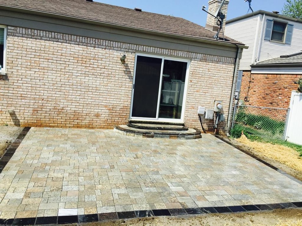Design ideas for a medium sized rustic back patio in Detroit with natural stone paving and no cover.