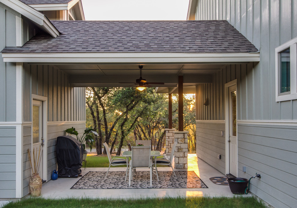 Immagine di un patio o portico american style di medie dimensioni e in cortile con lastre di cemento e un tetto a sbalzo
