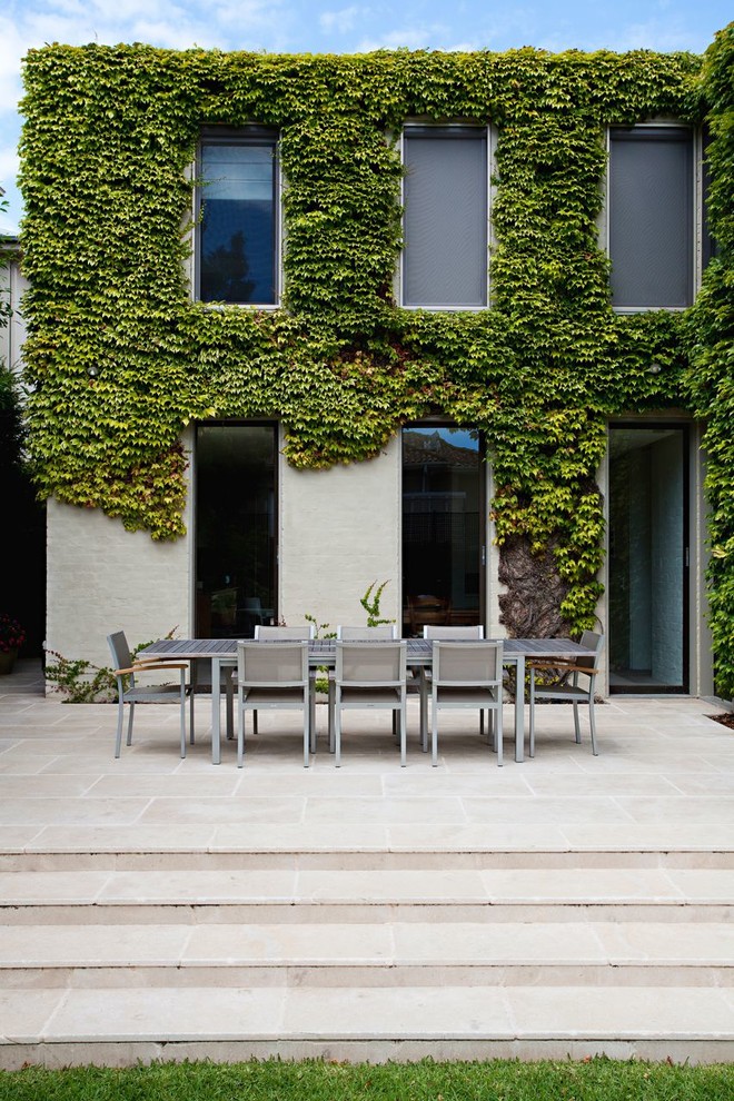 На фото: большой двор на заднем дворе в современном стиле с покрытием из каменной брусчатки без защиты от солнца