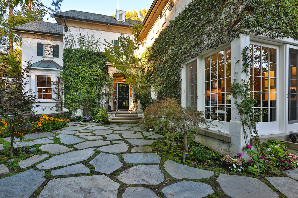 Imagen de patio clásico con jardín vertical y adoquines de piedra natural