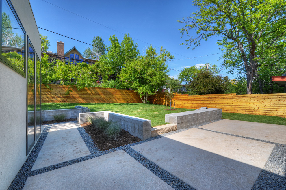 Inspiration for a modern backyard concrete paver patio remodel in Denver with no cover