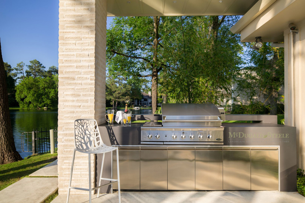 Inspiration for a contemporary concrete patio kitchen remodel in Houston with a pergola
