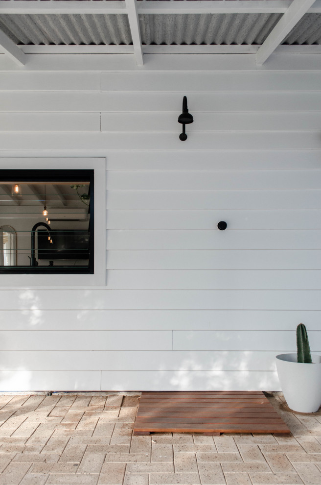 Inspiration pour une terrasse avec une douche extérieure arrière design de taille moyenne avec des pavés en brique et une pergola.
