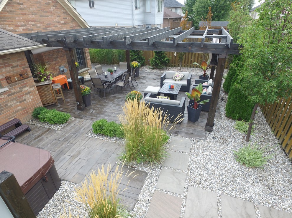 Foto de patio exótico grande en patio trasero con gravilla y pérgola