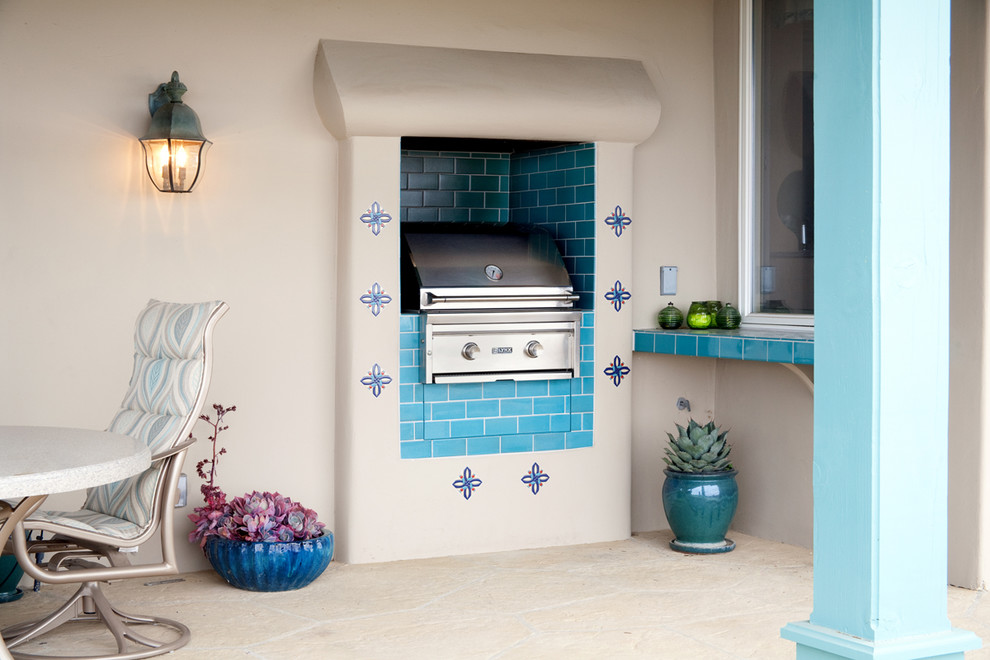 Example of a mid-sized tuscan backyard stone patio kitchen design in Santa Barbara with a roof extension