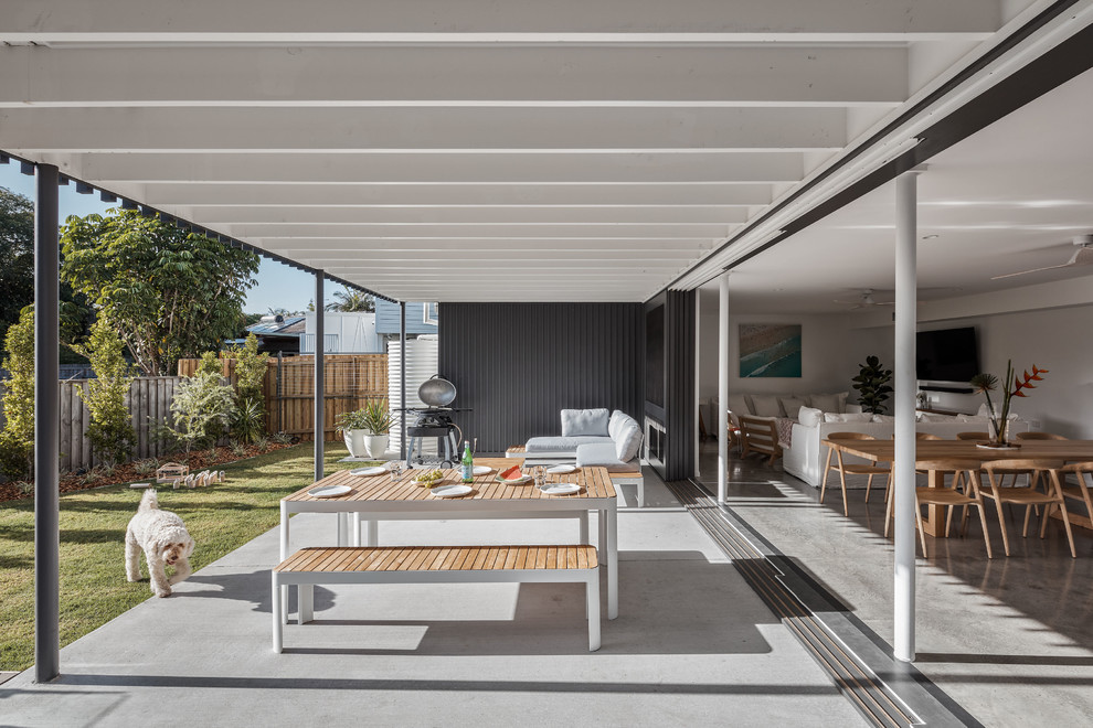 Immagine di un patio o portico stile marino dietro casa con un tetto a sbalzo