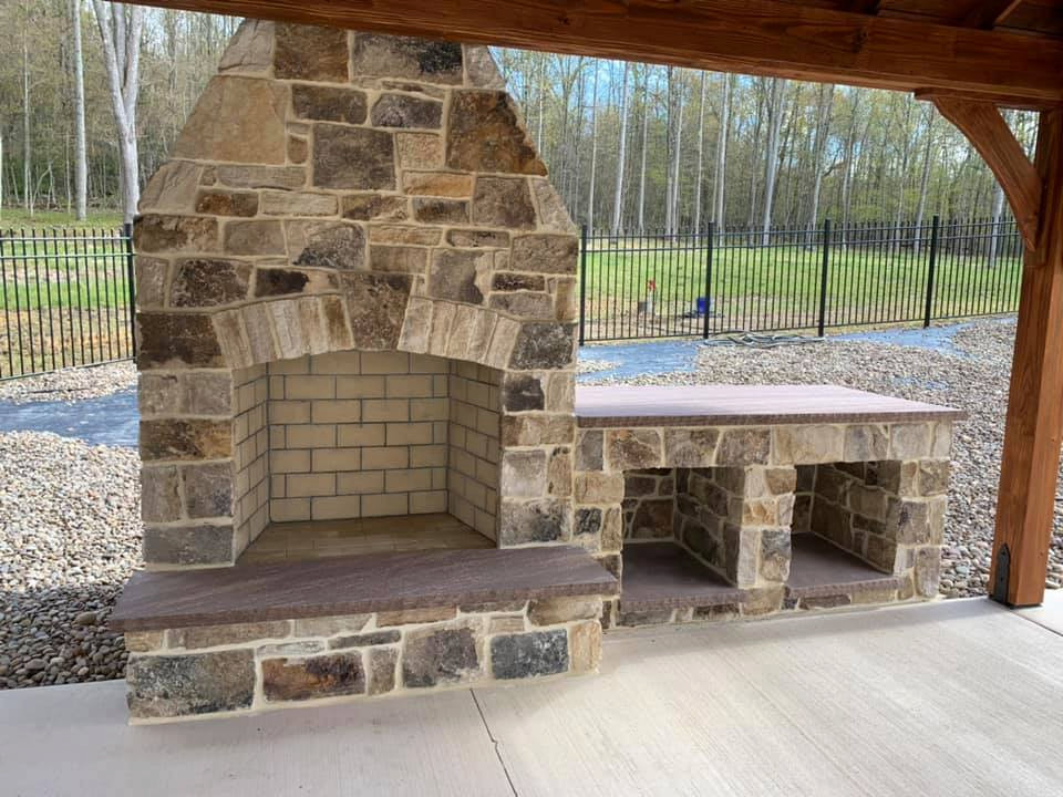 Patio - large traditional backyard concrete patio idea in Other with a fireplace and a gazebo