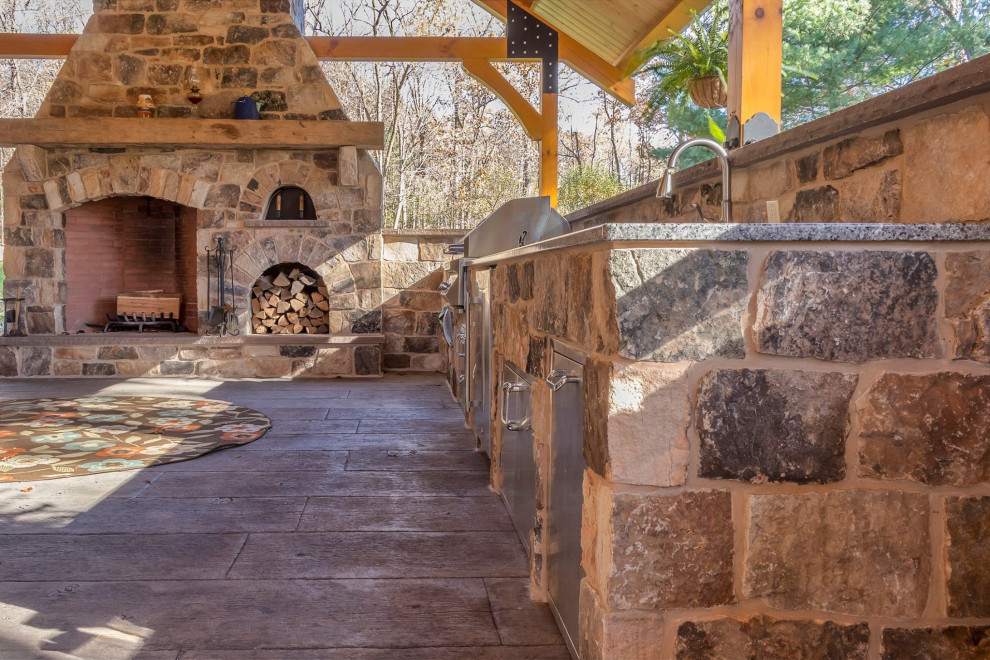 Esempio di un grande patio o portico tradizionale dietro casa con un caminetto, pavimentazioni in pietra naturale e un gazebo o capanno