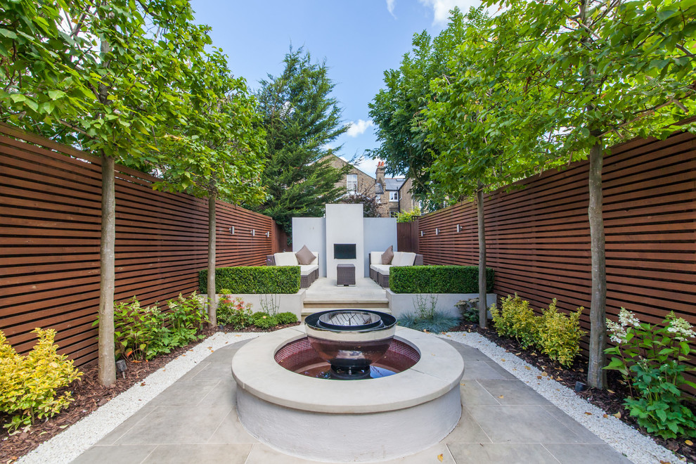 Diseño de patio contemporáneo sin cubierta en patio trasero con fuente