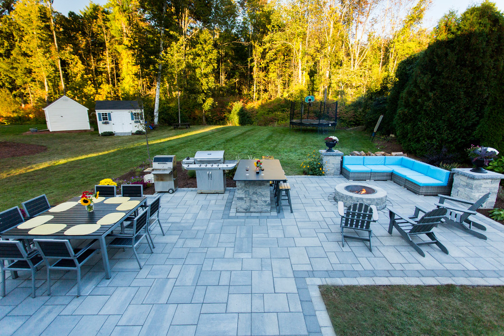 Mid-sized trendy backyard concrete paver patio photo in Manchester with a fire pit and no cover