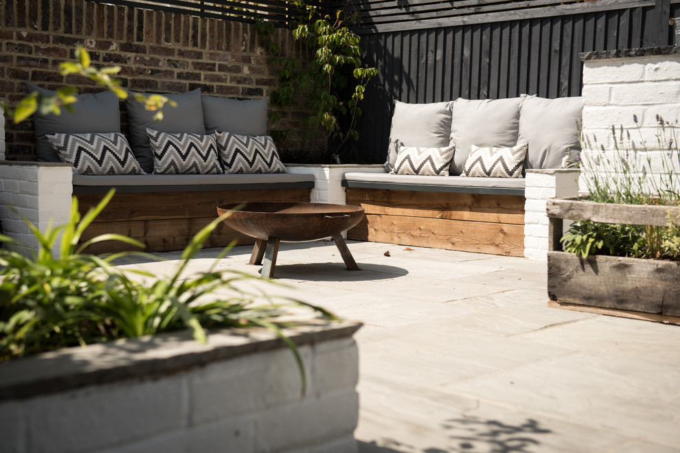 Design ideas for a contemporary back patio in Sussex with concrete slabs and no cover.