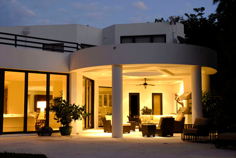 Inspiration pour une grande terrasse arrière design avec une cuisine d'été, une extension de toiture et des pavés en pierre naturelle.