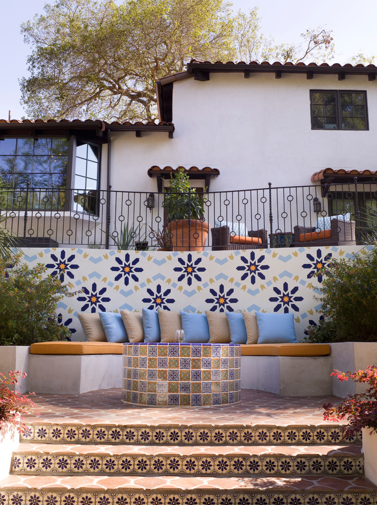 Foto de patio mediterráneo grande sin cubierta en patio trasero con fuente y suelo de baldosas