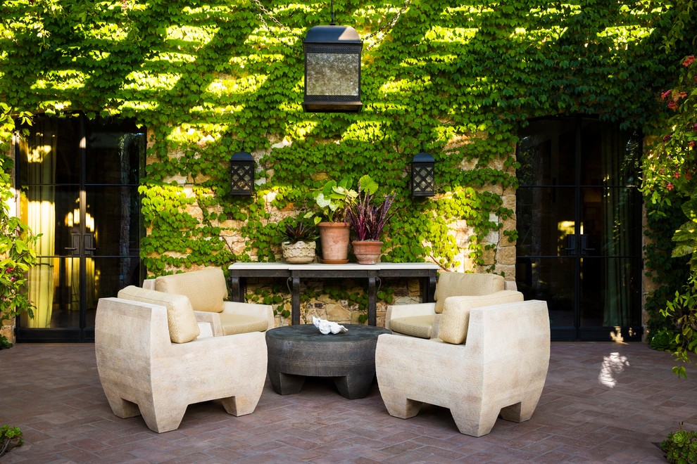 Idée de décoration pour une terrasse avec des plantes en pots méditerranéenne avec des pavés en brique.