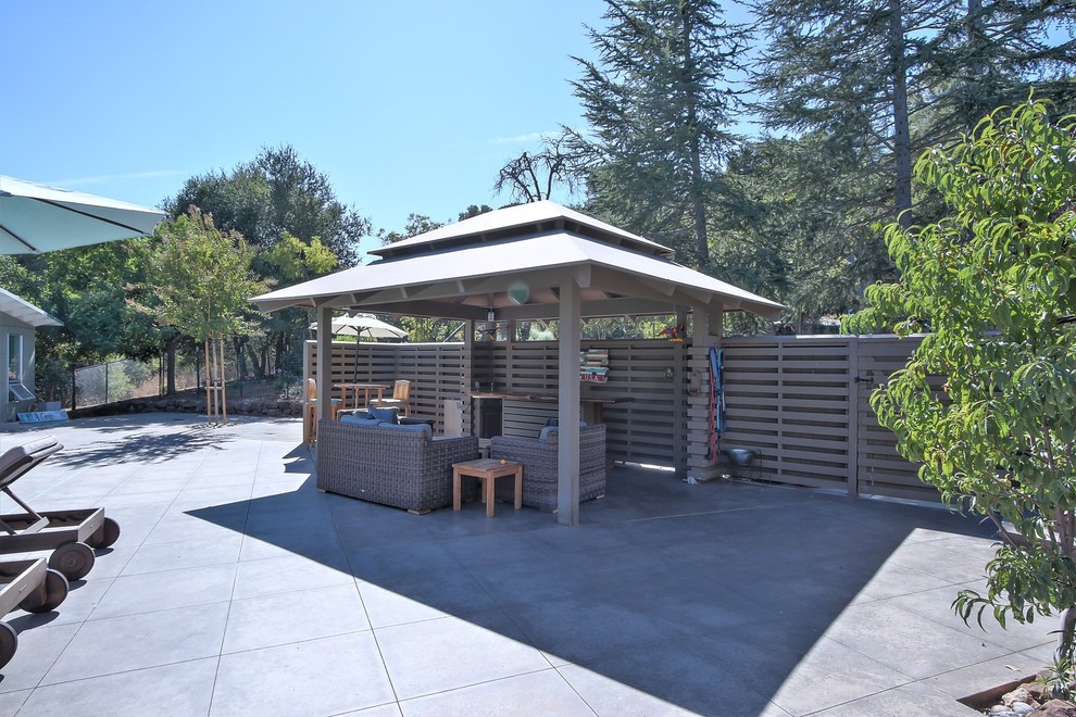 This is an example of a contemporary back patio in San Francisco with concrete paving and a gazebo.