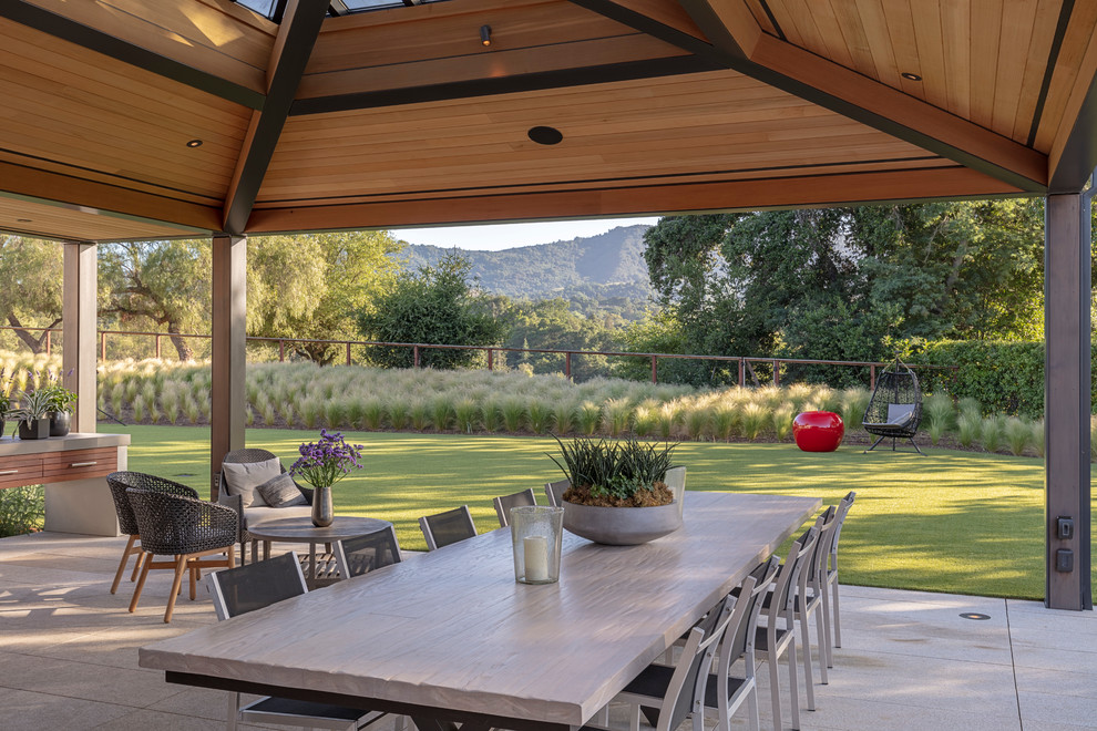Идея дизайна: большой двор на заднем дворе в современном стиле с летней кухней, покрытием из каменной брусчатки и навесом