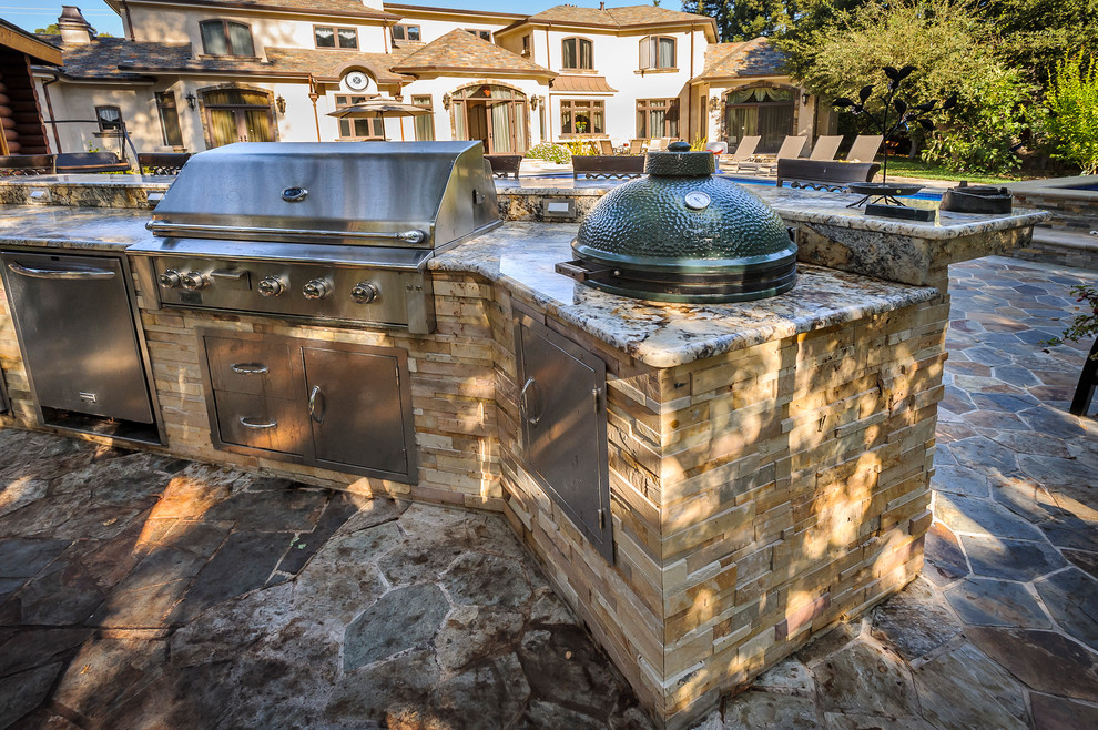 Example of a large classic backyard stone patio kitchen design in San Francisco with no cover