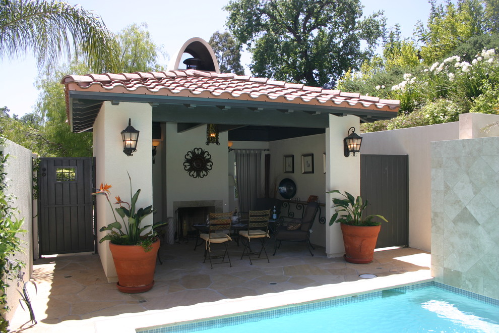 Inspiration pour une grande terrasse arrière méditerranéenne avec des pavés en pierre naturelle, un foyer extérieur et un gazebo ou pavillon.