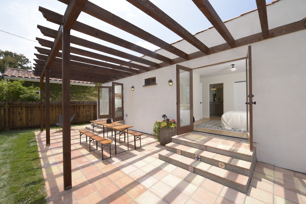 Medium sized mediterranean back patio in Los Angeles with a pergola and tiled flooring.