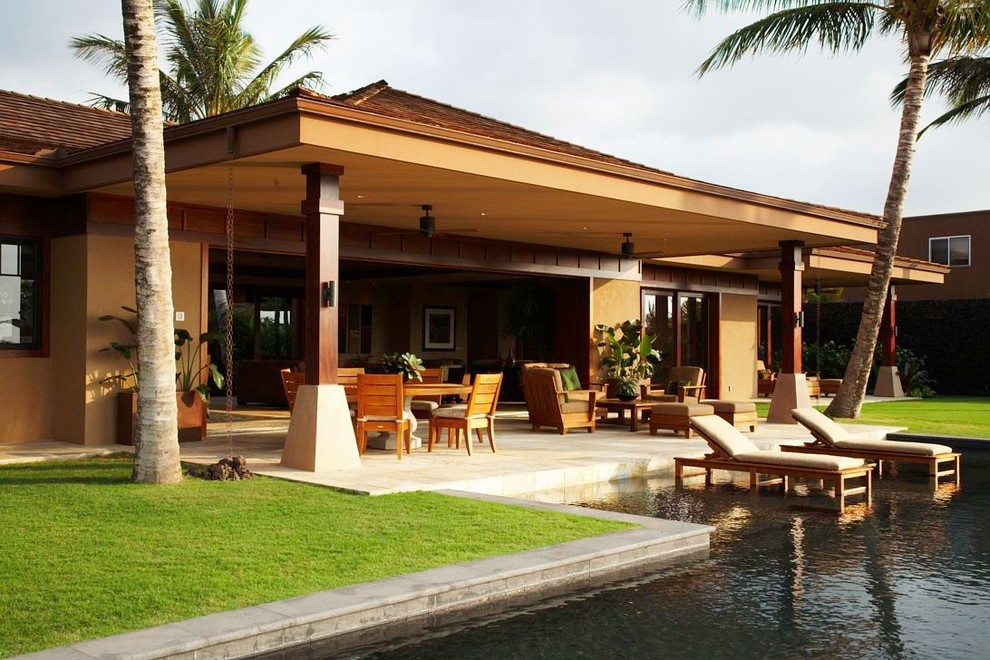 Idee per un patio o portico tropicale con un tetto a sbalzo