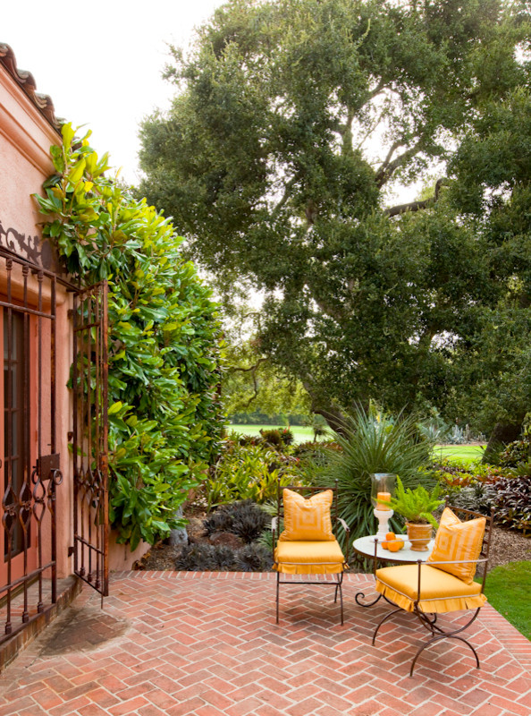 Example of a large tuscan courtyard brick patio fountain design in Santa Barbara with no cover