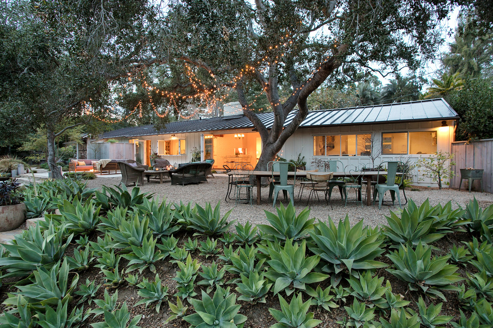 Ejemplo de patio de estilo de casa de campo grande sin cubierta en patio trasero con brasero y adoquines de hormigón