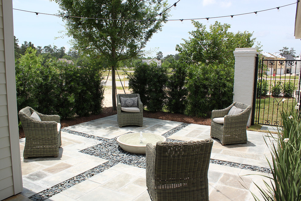 Inspiration pour une terrasse design avec un point d'eau, une cour et des pavés en pierre naturelle.