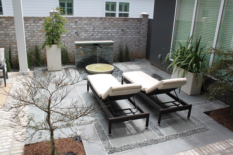 Идея дизайна: двор на внутреннем дворе в современном стиле с фонтаном и покрытием из плитки