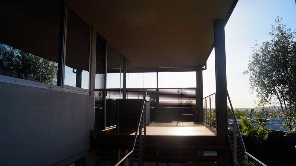Idee per un patio o portico moderno nel cortile laterale e di medie dimensioni con pedane e un tetto a sbalzo