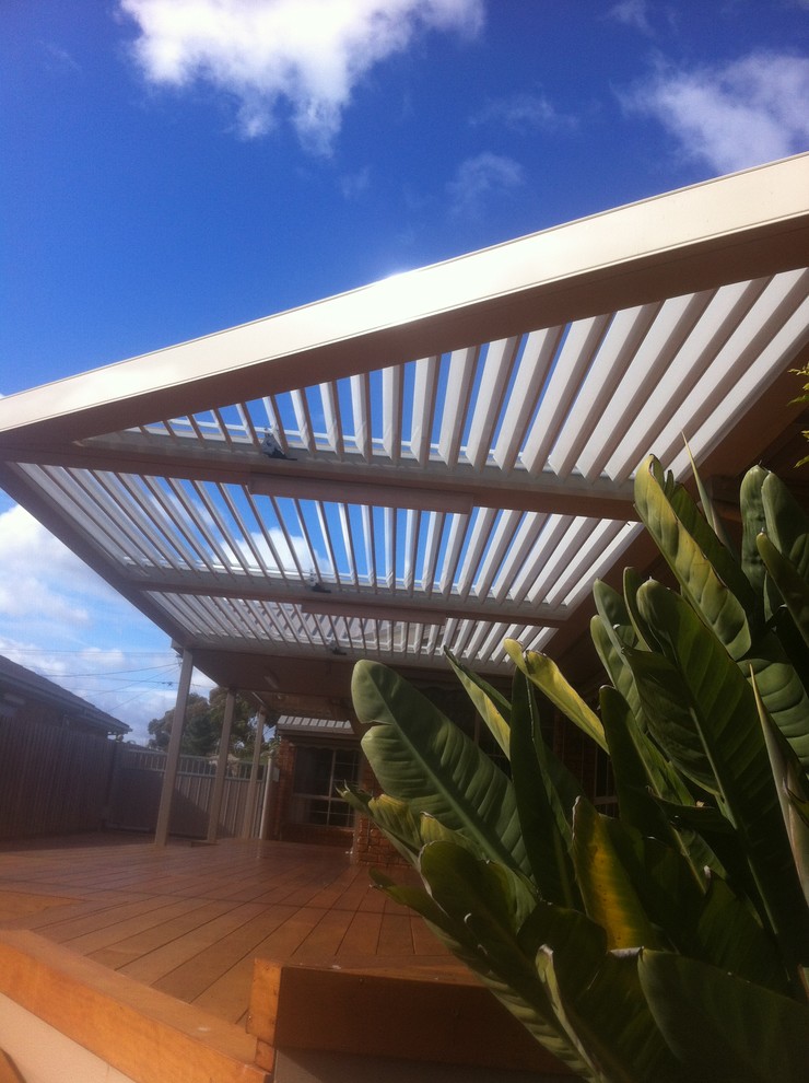 Inspiration pour une terrasse latérale minimaliste avec une extension de toiture.