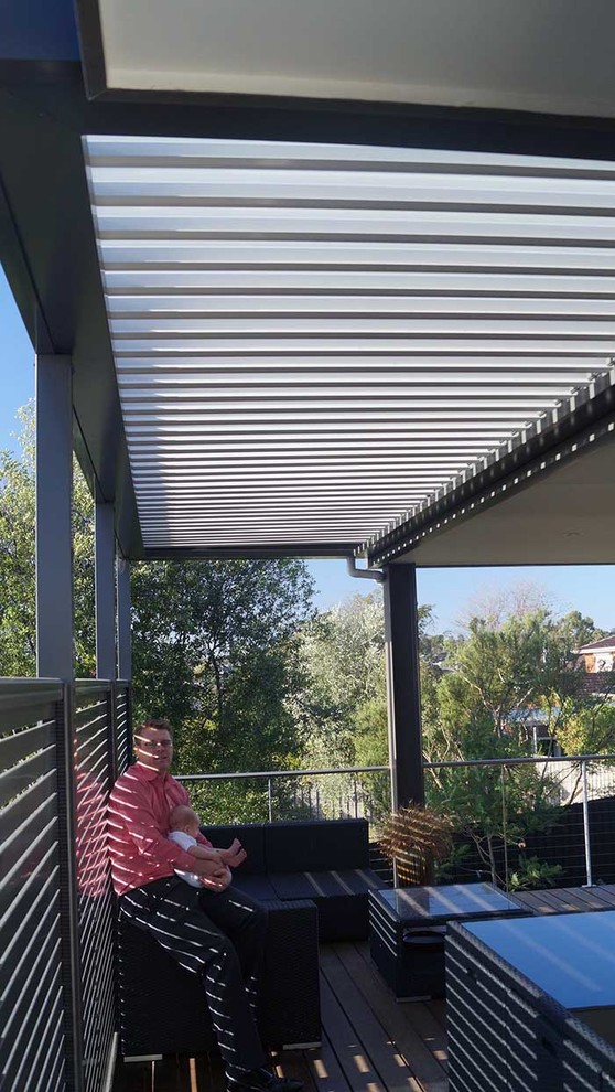 Immagine di un patio o portico minimalista di medie dimensioni e nel cortile laterale con pedane e un tetto a sbalzo