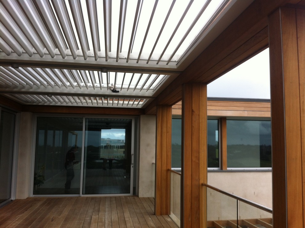 Réalisation d'une terrasse arrière minimaliste avec une cuisine d'été et une extension de toiture.